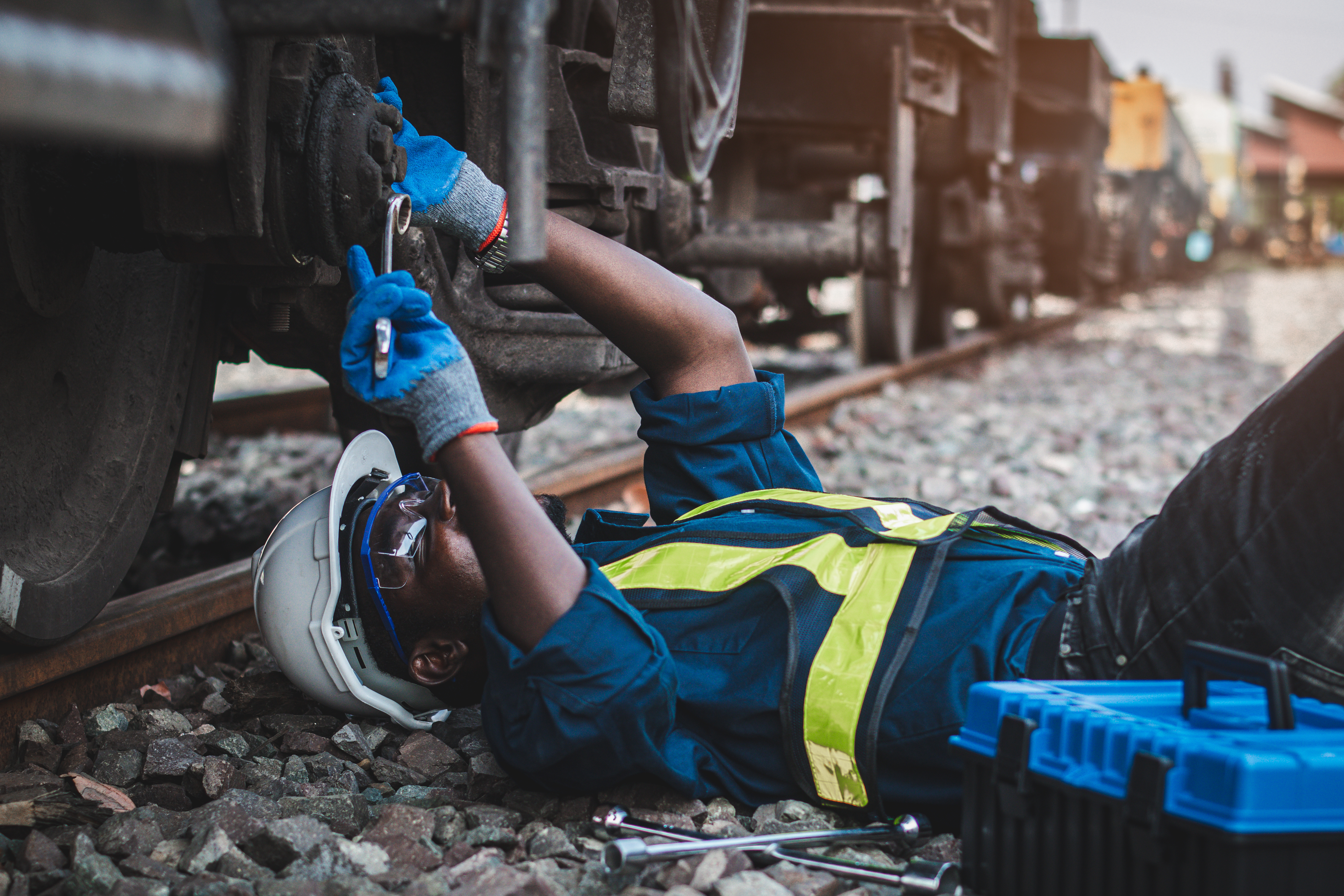 Male mechanic performing maintenance on a railcar with a wrench