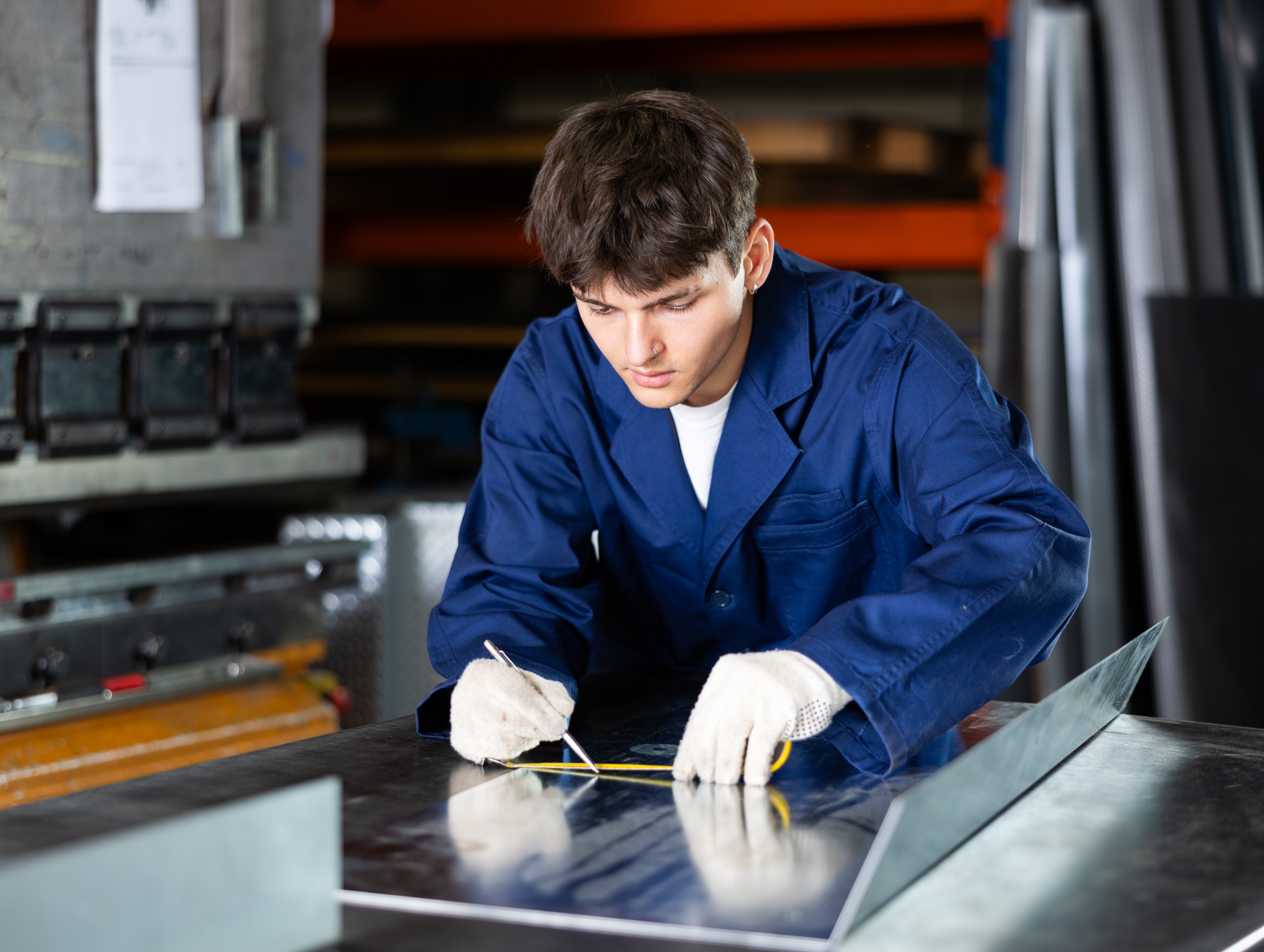 A man measuring the length of a metal alloy for work